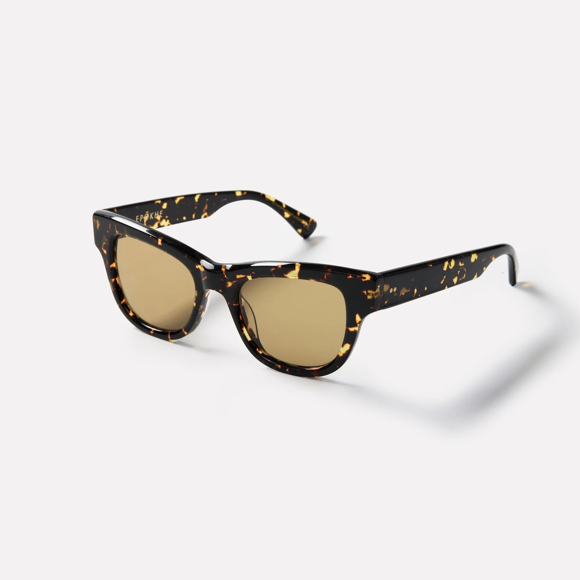 Sunglasses with tortoiseshell frame and gold lenses on a white background